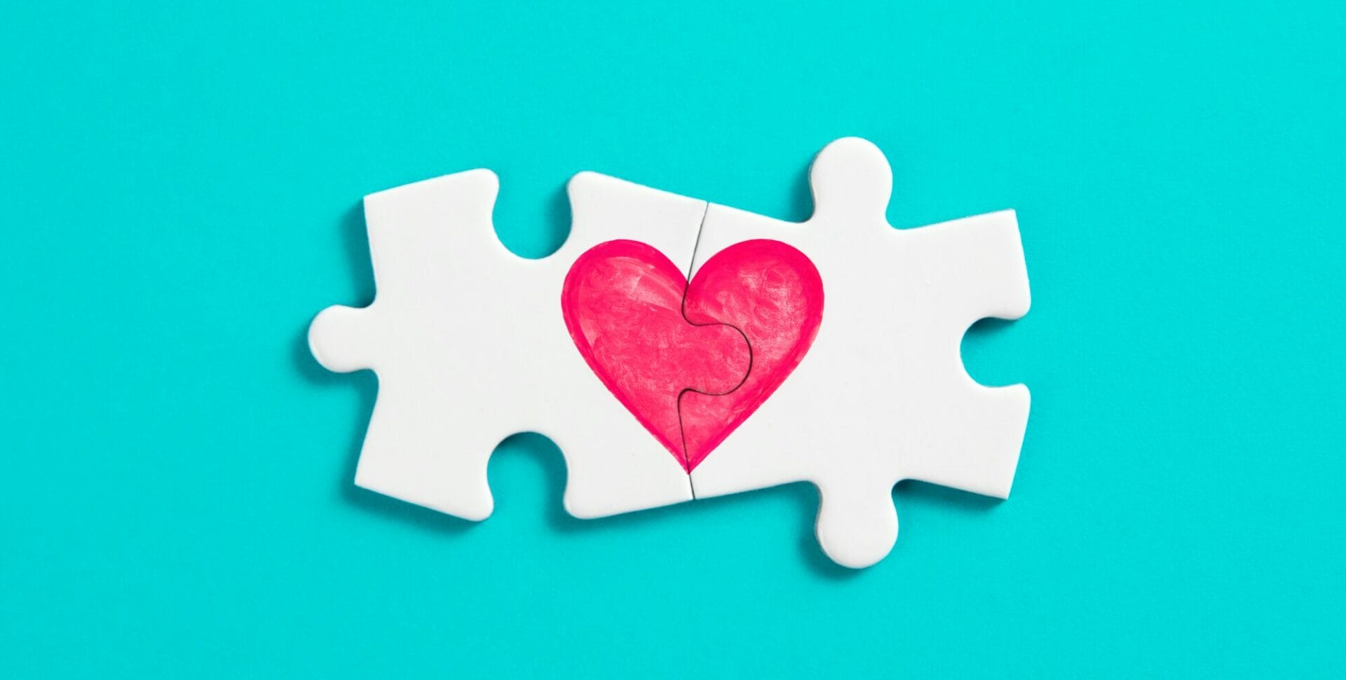 meaningful connection metaphor two jigsaw pieces connected to make a heart on a blue background