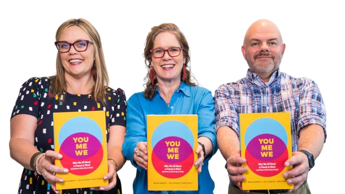 Ruby, Morag, and Eric holding copies of their book You Me We demonstrating workplace connection