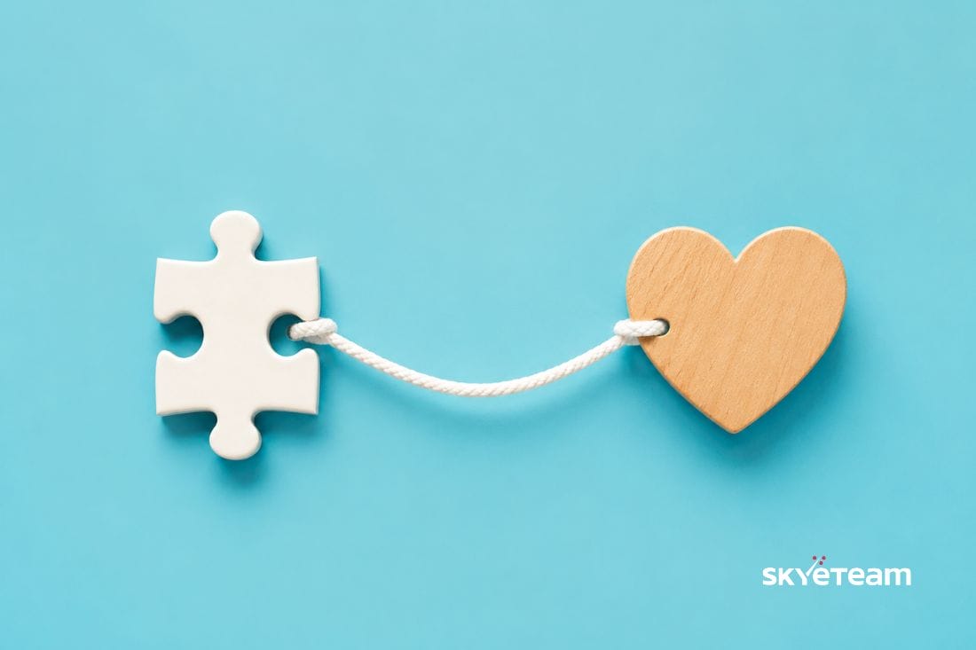 a jigsaw puzzle piece attached to a heart with a piece of string representing human connection