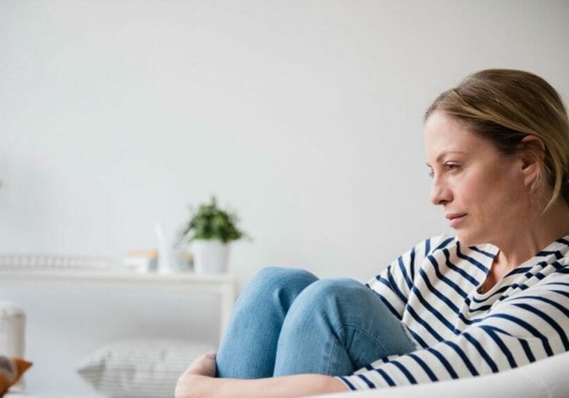 loneliness. woman sitting alone on a couch