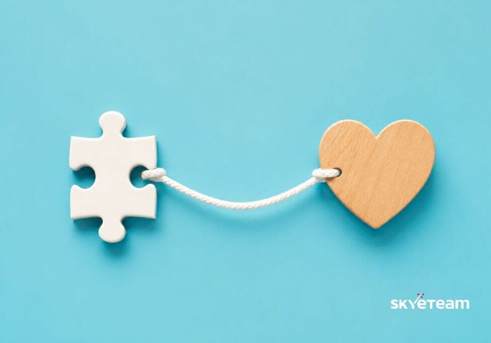 a jigsaw puzzle piece attached to a heart with a piece of string representing human connection
