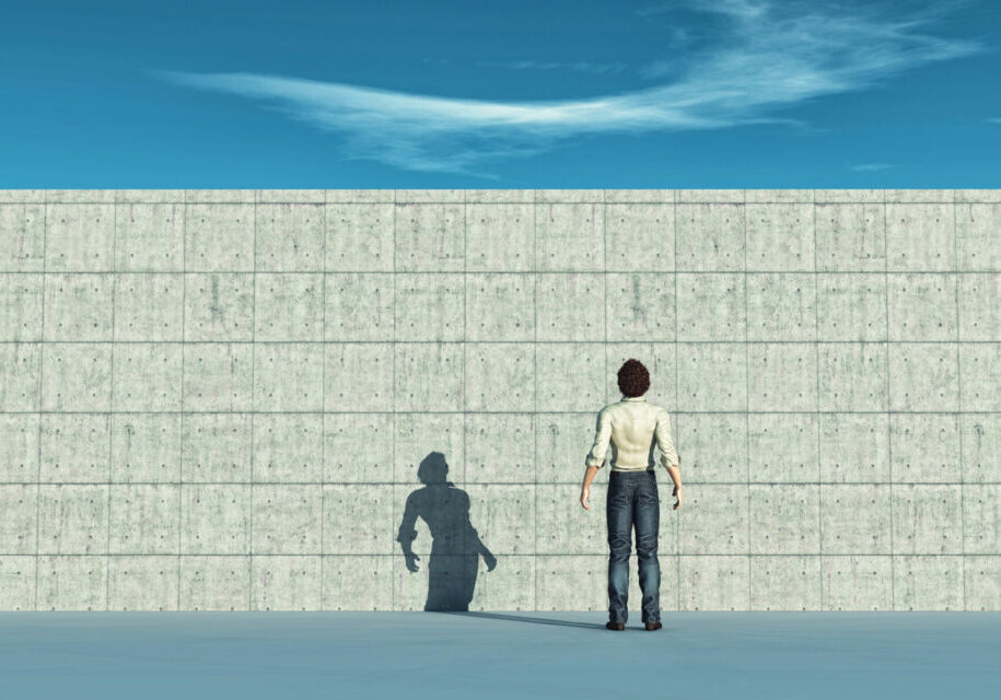 skyeteam image of a person standing facing a tall brick wall